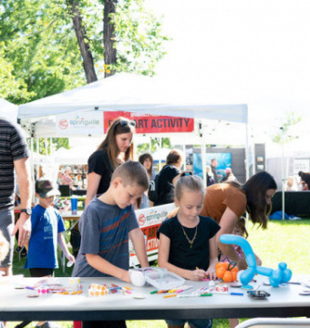 a family painting outdoors on tables