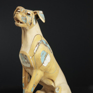 light-colored wood sculpture of a dog's face and neck